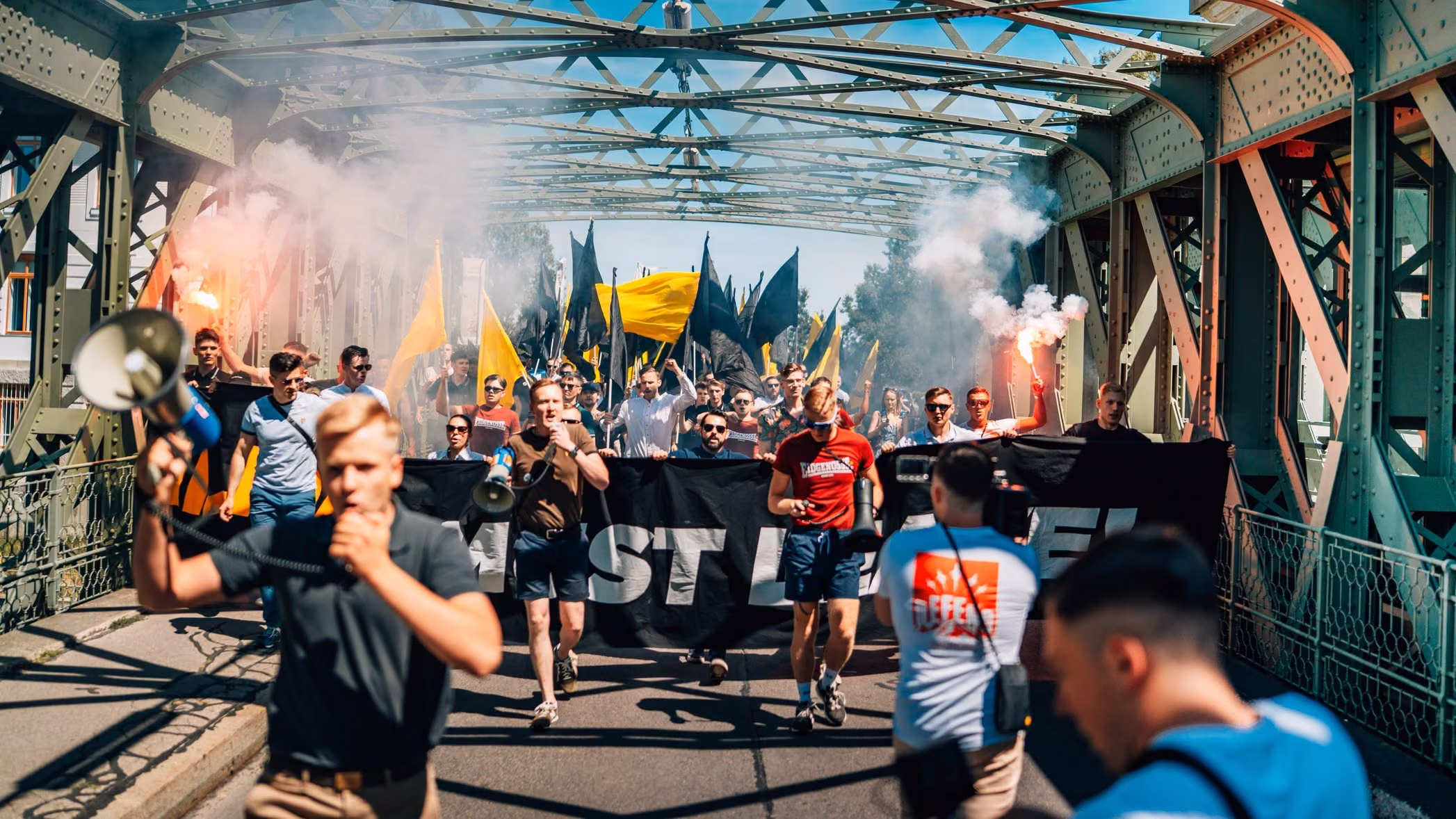 Demonstrationszug der Remigrationsdemo 2026 auf einer Brücke in Wien.